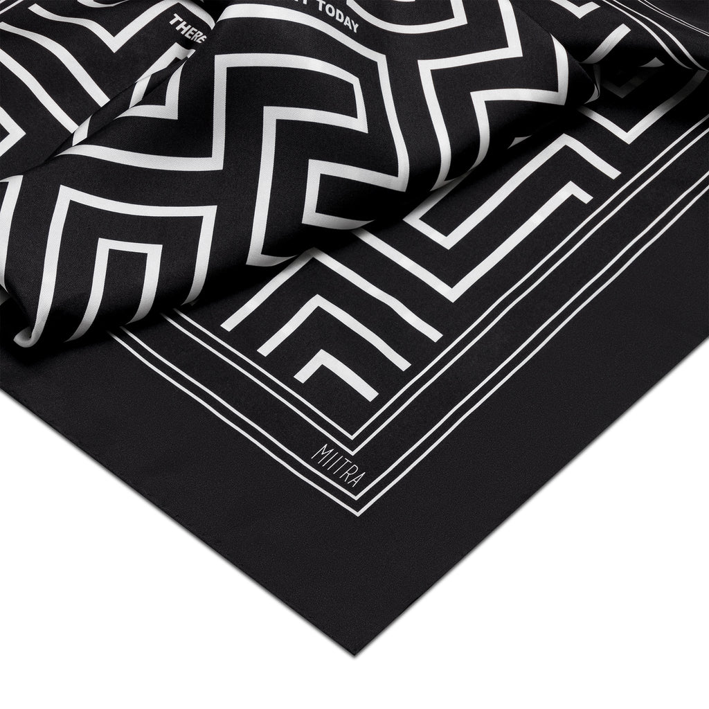 Proverbs Silk Scarf - detail shot of black silk scarf with close up of logo