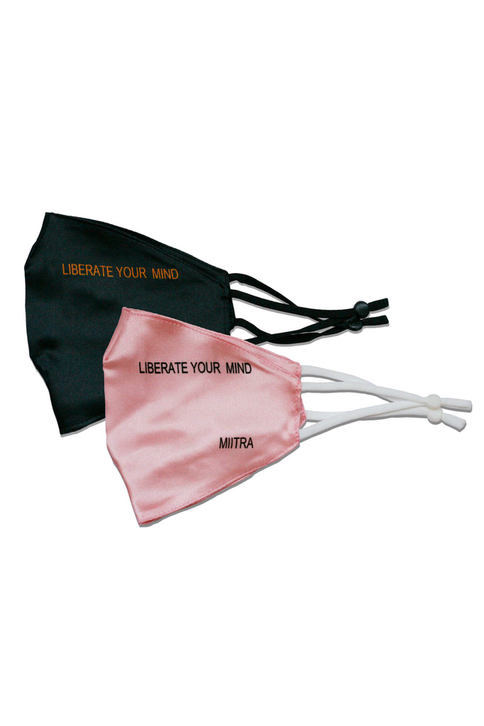 Black and pink silk face masks paired together. Liberate your mind is printed on both face masks.