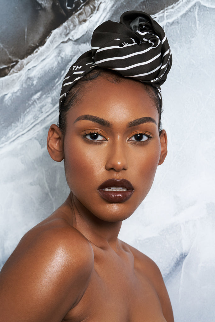 Woman wearing an olive green silk scarf as a headwrap.